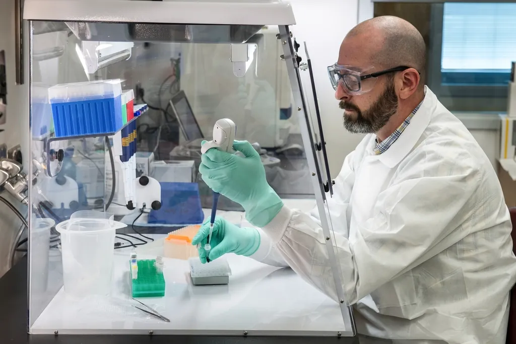 Technicien de laboratoire travaillant sous une hotte de sécurité